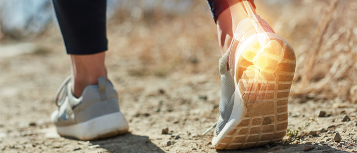 person's feet walking outside with right ankle highlighted in pain