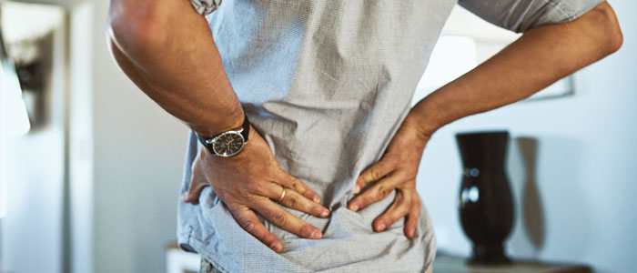 man holding low back in pain